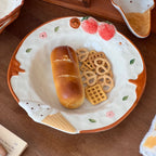 Piatto in ceramica goffrata, modellato a forma di fragola e dipinto a mano.